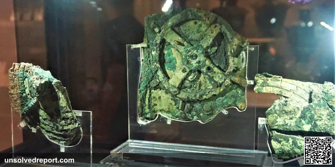 The corroded bronze Antikythera Mechanism, an ancient Greek geared analog computer dated to roughly 150-100 BC, at the National Archaeological Museum, Athens.
