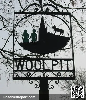 The village sign, showing the green children of Woolpit. Cropped from original
