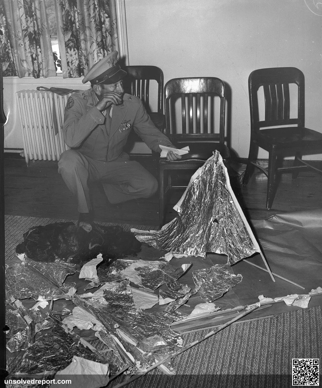 At Fort Worth Army Air Field, Brig. General Roger Ramey, holding telegram, inspects debris brought back from Roswell, N…